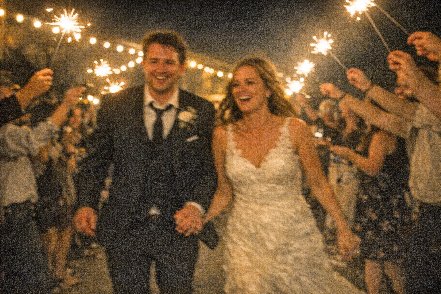 Grainy nighttime wedding sparkler exit